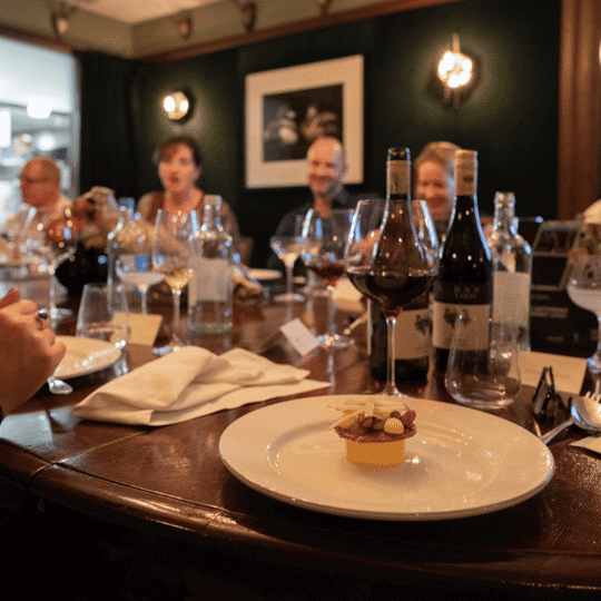 Desserts focused on a plate with a group of guests behind