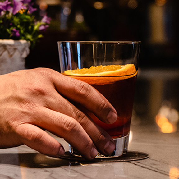 Man holding a cocktail on a bar