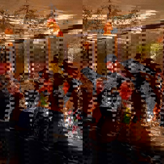 Waiters serving a table of people in a candle lit restaurant