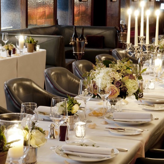 Long table laid at Corrigan's Mayfair with flower centrepieces and candles