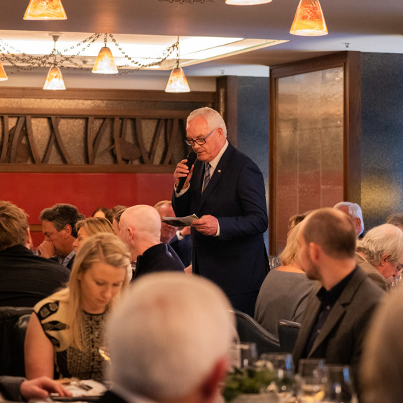 Gentleman speaking into a microphone in a restaurant