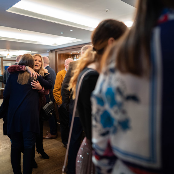 Women hugging by a group of people