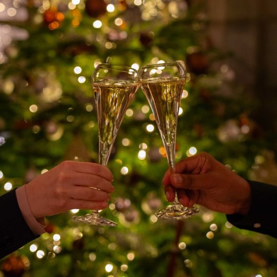 Two champagne glasses clinking