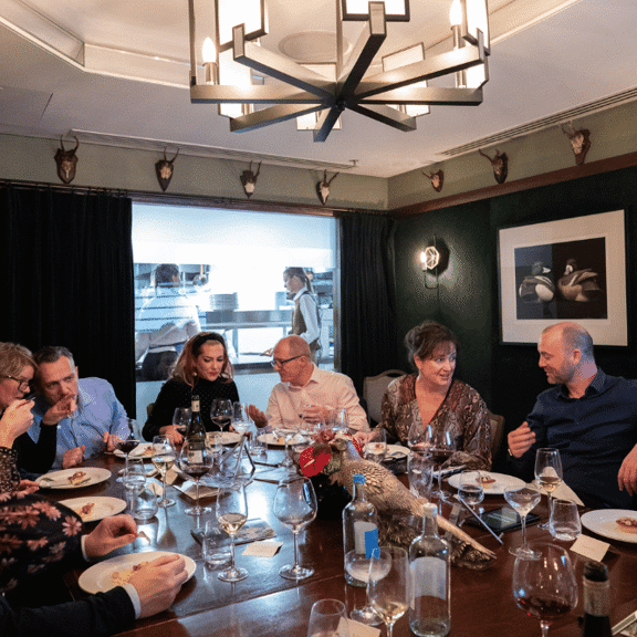 Group of guests having a birthday celebration round a table at Corrigan's Mayfair
